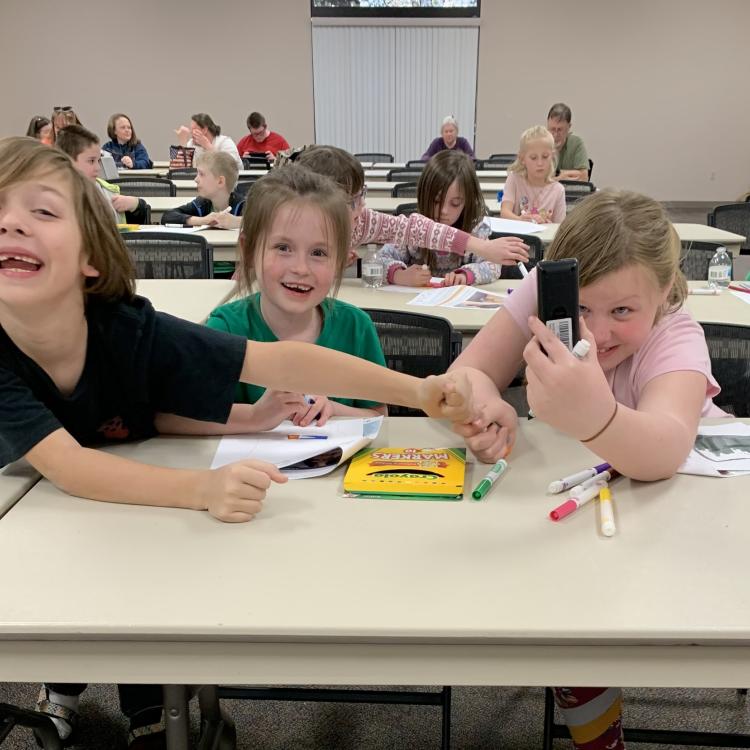  kids smiling and coloring