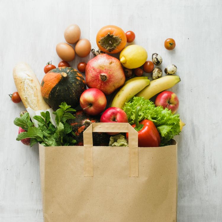  Paper bag of different health food on white wooden background